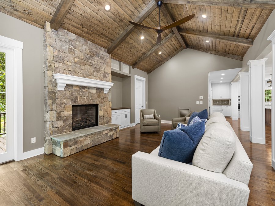 Great room with a stone fireplace and a vaulted timber ceiling