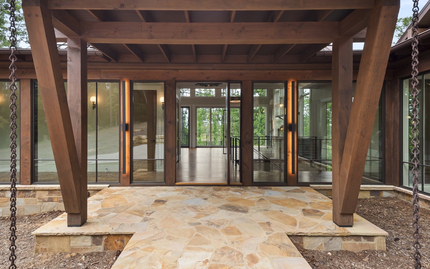 Timber entry portico with a flagstone path and glass doors into the home